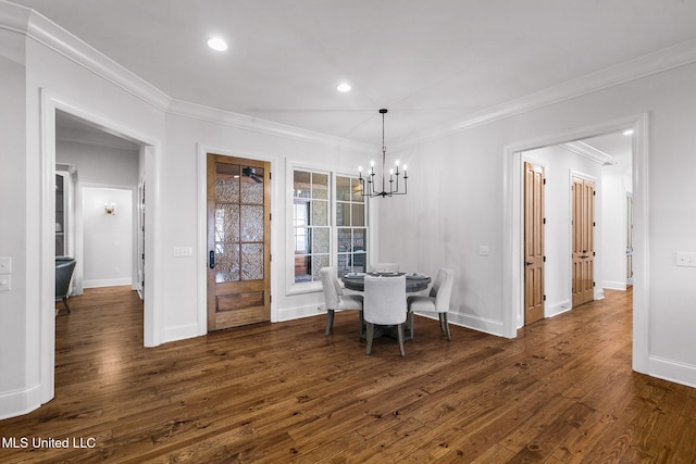 dining room with a notable chandelier, ornamental molding, and dark hardwood / wood-style flooring