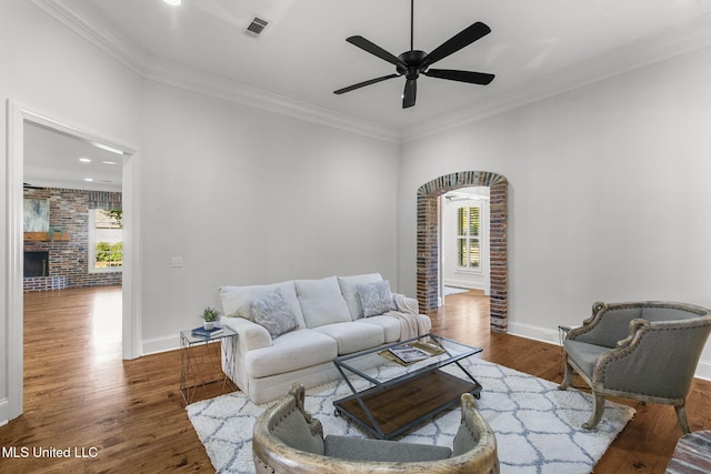 living room featuring ornamental molding, a healthy amount of sunlight, wood-type flooring, and ceiling fan