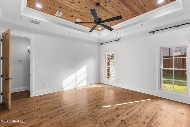 empty room featuring crown molding, wood-type flooring, a tray ceiling, and ceiling fan