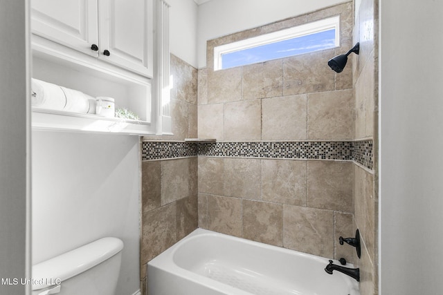 bathroom featuring toilet and tiled shower / bath