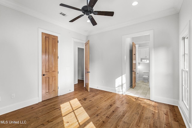 unfurnished bedroom featuring crown molding, light hardwood / wood-style flooring, ceiling fan, and ensuite bath