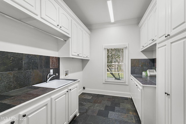 washroom featuring crown molding, washer hookup, sink, and cabinets