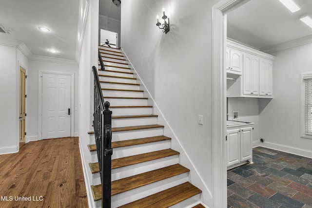 stairway featuring crown molding and hardwood / wood-style floors