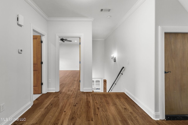 corridor with dark wood-type flooring and crown molding