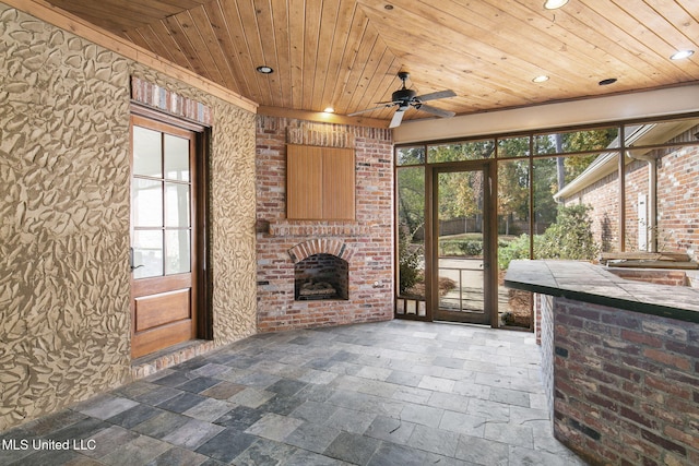 interior space with wooden ceiling, a fireplace, and ceiling fan