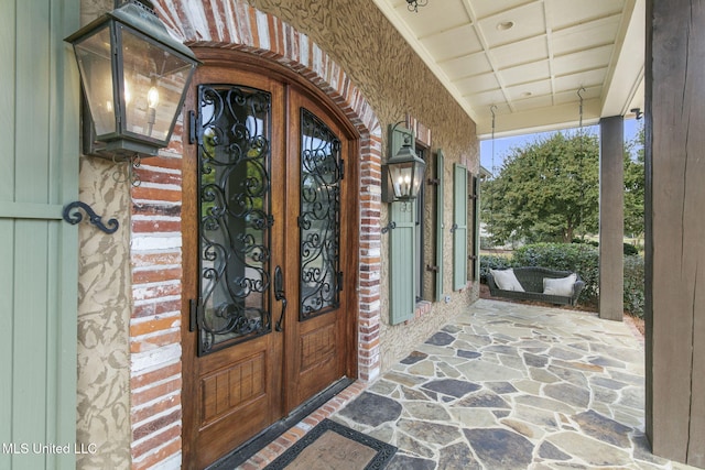 view of exterior entry featuring covered porch