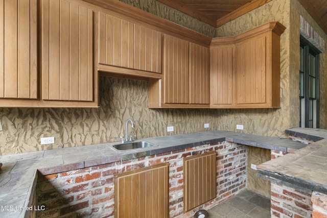 kitchen with tasteful backsplash, tile patterned floors, and sink