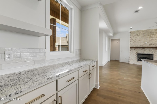 101 Harbour Lndg, Madison, MS 39110 - kitchen with tasteful backsplash, open floor plan, white cabinets, dark wood-type flooring, and light stone countertops