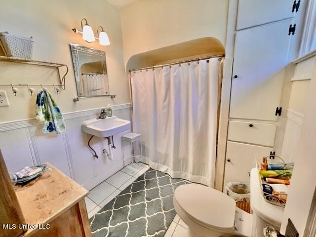 bathroom with walk in shower, toilet, tile patterned floors, and sink