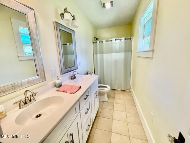 bathroom featuring toilet, vanity, plenty of natural light, and tile patterned flooring