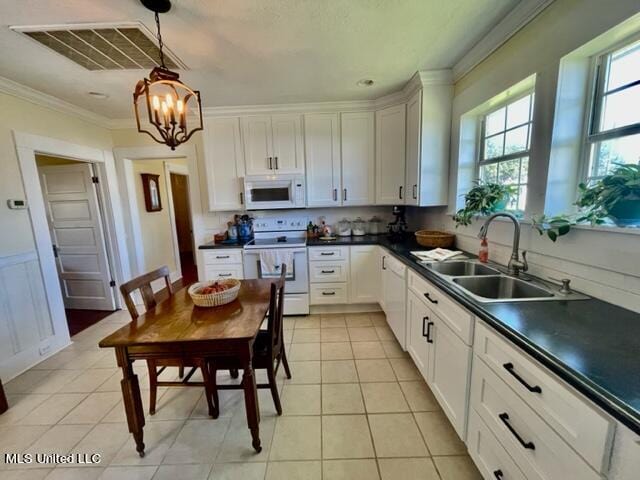 kitchen featuring sink, decorative light fixtures, light tile patterned floors, white cabinets, and white appliances