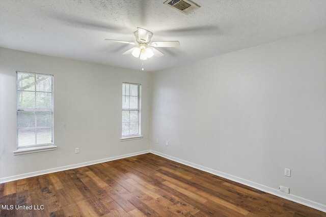 unfurnished room with ceiling fan, hardwood / wood-style floors, a textured ceiling, and a wealth of natural light