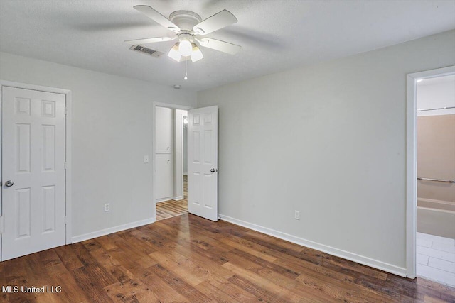 unfurnished bedroom featuring dark wood-type flooring and ceiling fan