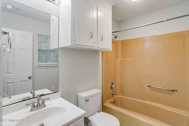 full bathroom featuring washtub / shower combination, vanity, toilet, and a textured ceiling