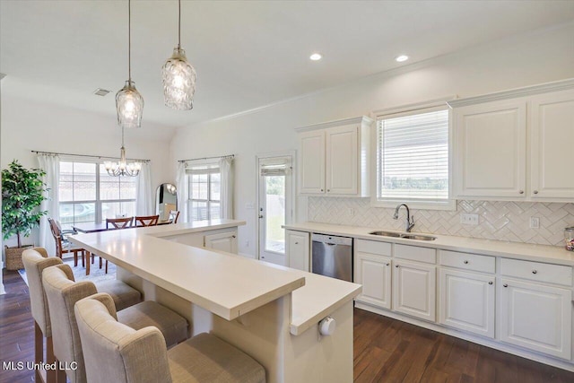 200 Falls Xing, Madison, MS 39110 - kitchen with stainless steel dishwasher, dark wood-style floors, decorative backsplash, a kitchen bar, and light countertops