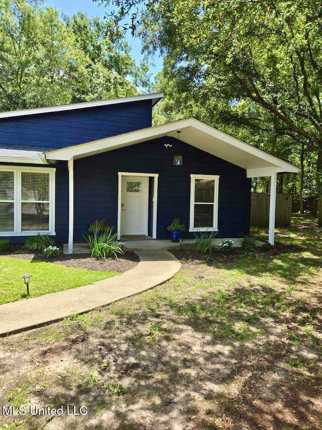 single story home featuring a front lawn and covered porch