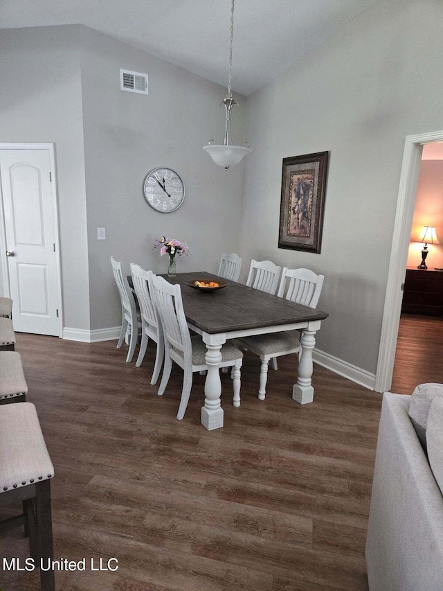 dining space with lofted ceiling and dark wood-type flooring