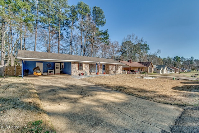 view of front of property featuring fence, a front lawn, and concrete driveway