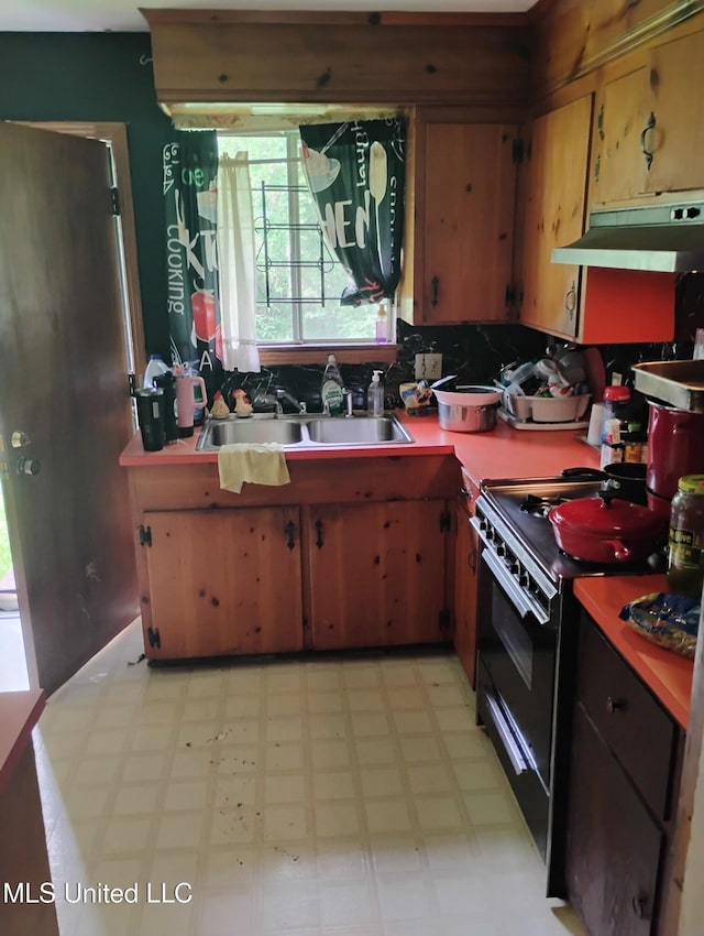 kitchen with electric range, a sink, decorative backsplash, light floors, and under cabinet range hood
