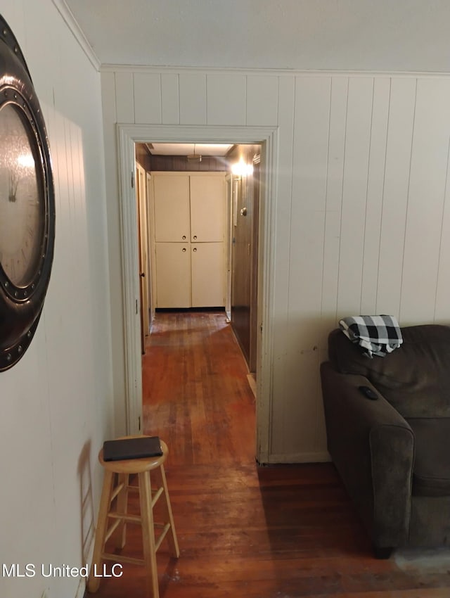 hall with dark wood-style floors and ornamental molding
