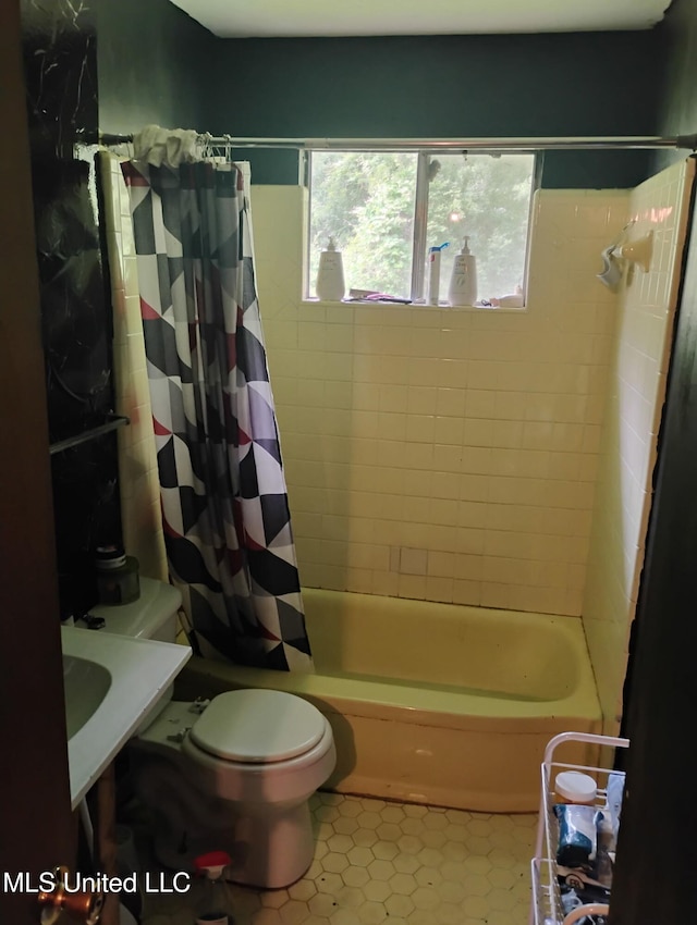 bathroom featuring shower / bath combo with shower curtain, tile patterned floors, and toilet
