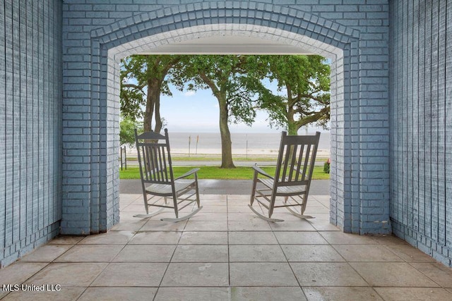 view of patio featuring a water view and a beach view
