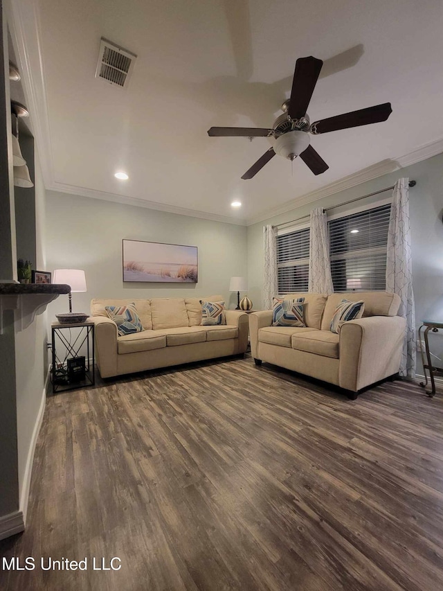 living room featuring wood finished floors, a ceiling fan, visible vents, baseboards, and ornamental molding