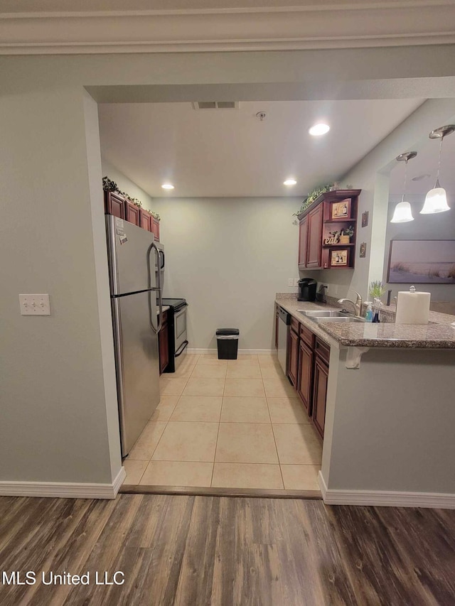 kitchen with light stone countertops, a sink, open shelves, stainless steel appliances, and light wood-type flooring