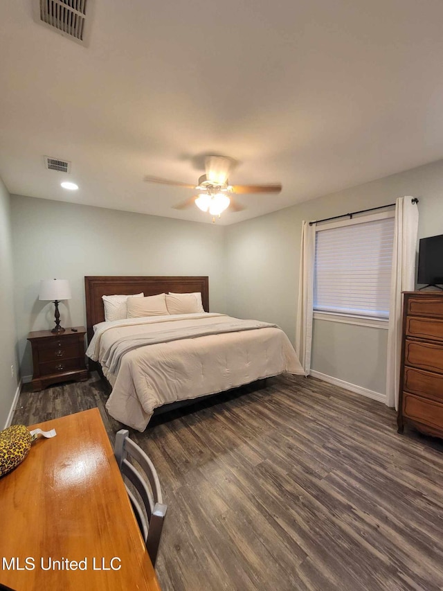 bedroom with baseboards, ceiling fan, visible vents, and wood finished floors