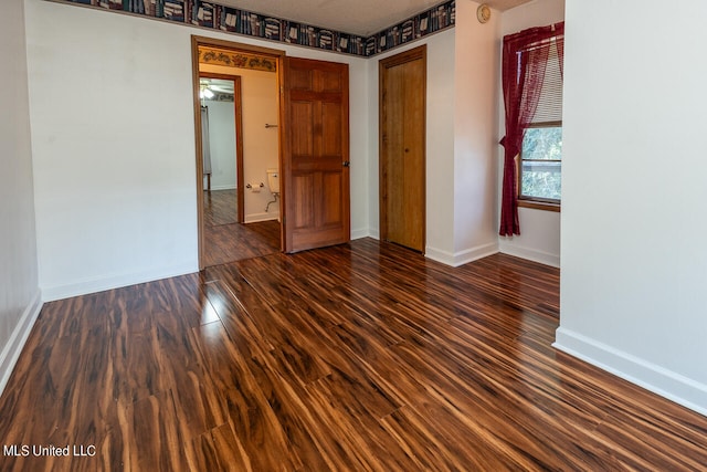 empty room featuring dark hardwood / wood-style flooring