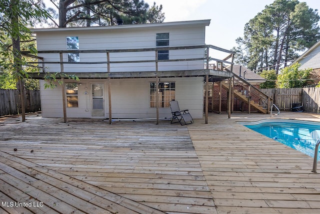 rear view of property featuring a swimming pool side deck