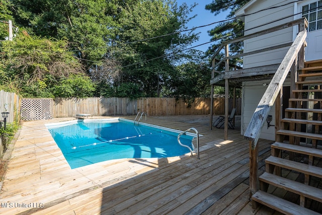 view of pool featuring a wooden deck and a diving board