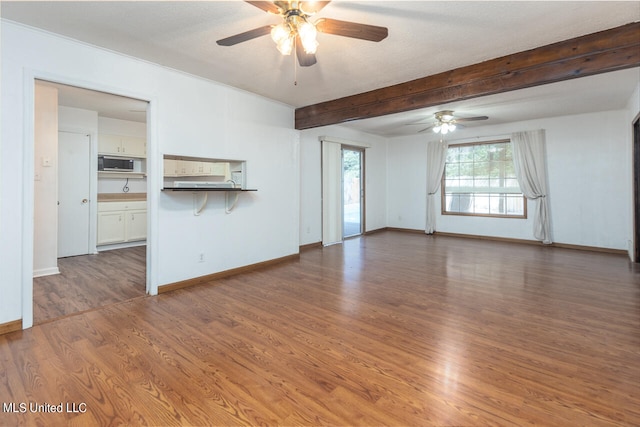 unfurnished living room featuring ceiling fan, a textured ceiling, beam ceiling, and dark hardwood / wood-style floors