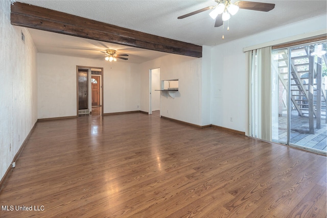 spare room with a textured ceiling, dark hardwood / wood-style floors, beamed ceiling, and ceiling fan