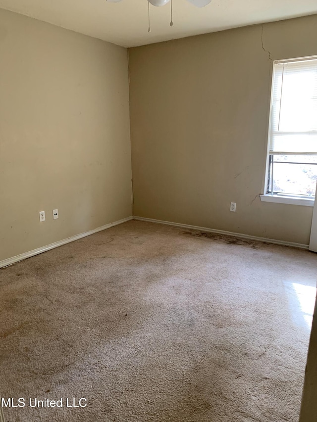 unfurnished room with baseboards and ceiling fan