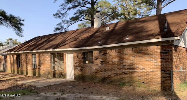 back of property featuring brick siding