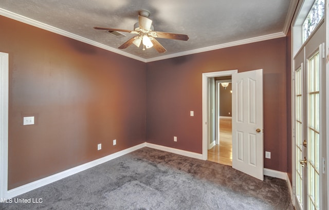 spare room featuring ceiling fan, crown molding, and carpet flooring