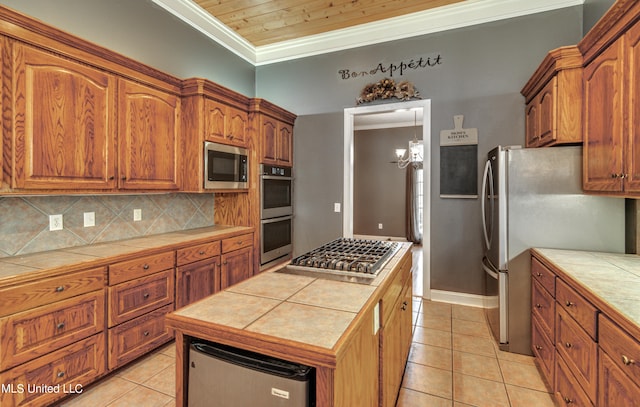 kitchen with tile countertops, tasteful backsplash, appliances with stainless steel finishes, and light tile patterned floors