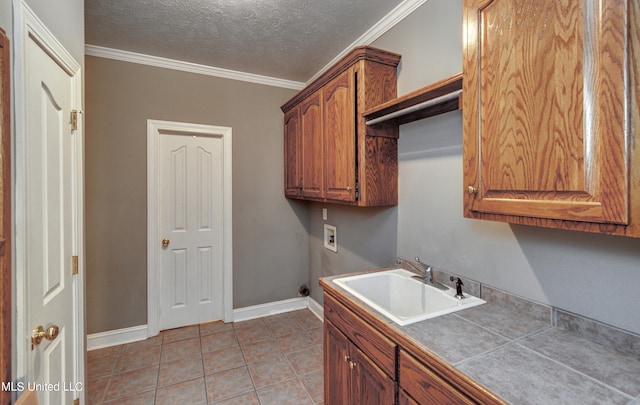 washroom featuring cabinets, washer hookup, a textured ceiling, ornamental molding, and sink