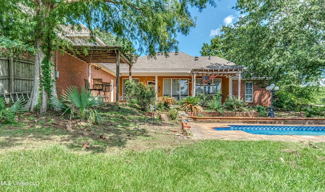 back of property featuring a patio area, a lawn, and a pergola