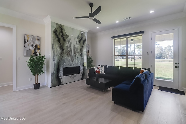 living room with crown molding, light hardwood / wood-style flooring, and a healthy amount of sunlight