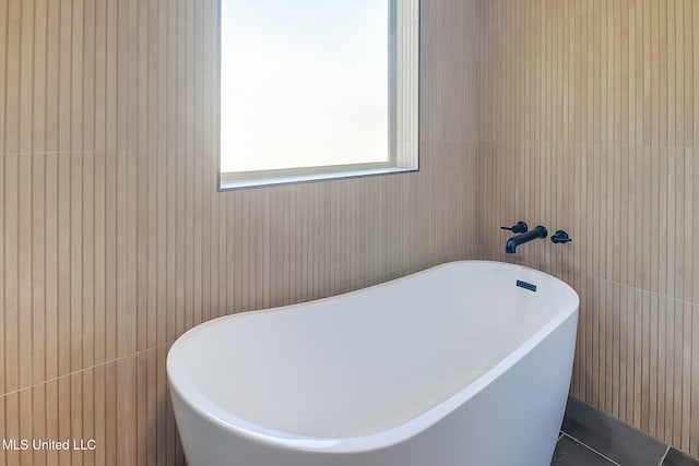 bathroom featuring a tub to relax in and tile patterned floors