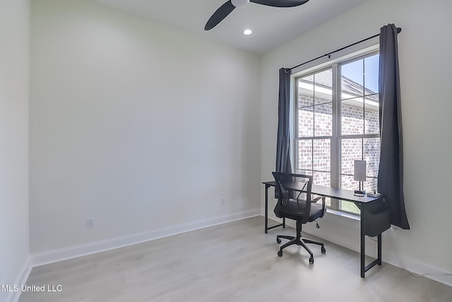 office with light wood-type flooring and ceiling fan