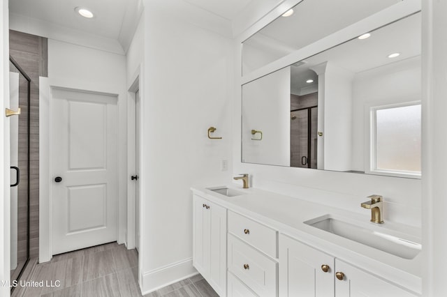 full bath featuring a shower stall, recessed lighting, double vanity, and baseboards