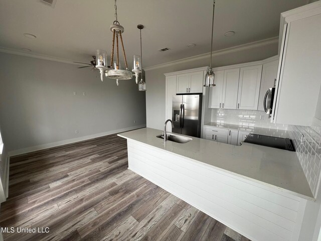 kitchen with stainless steel appliances, a sink, visible vents, decorative backsplash, and crown molding