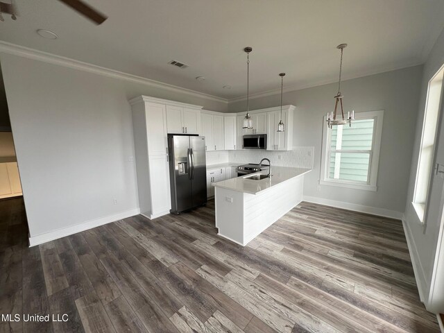 kitchen featuring stainless steel appliances, visible vents, backsplash, a sink, and a peninsula