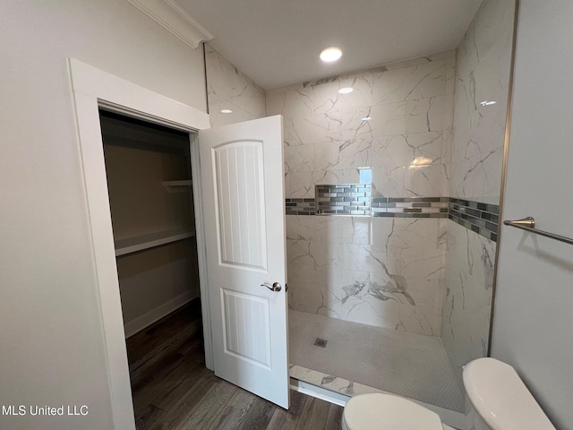 full bath with a marble finish shower, toilet, and wood finished floors