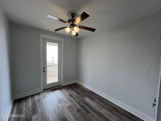 spare room featuring dark wood-type flooring, baseboards, and a ceiling fan