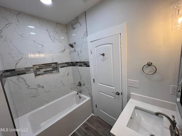 bathroom featuring vanity, wood finished floors, and washtub / shower combination