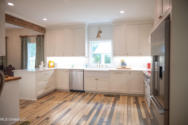 kitchen with stainless steel appliances, light hardwood / wood-style flooring, kitchen peninsula, and white cabinets